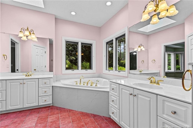 bathroom with vanity, tile patterned floors, a skylight, and a relaxing tiled tub