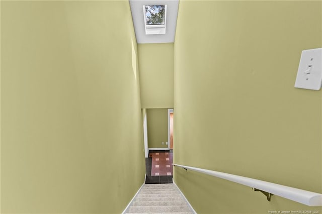 stairway featuring a skylight and carpet flooring