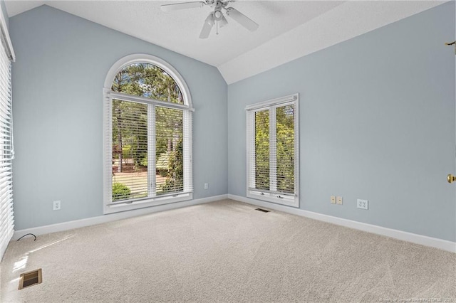 carpeted spare room with ceiling fan and lofted ceiling