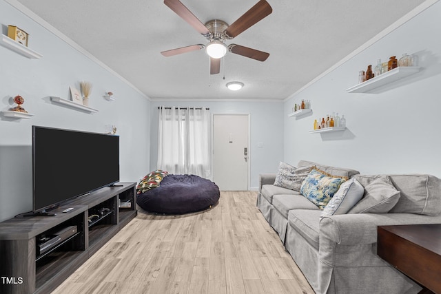 living room with crown molding, wood-type flooring, and ceiling fan