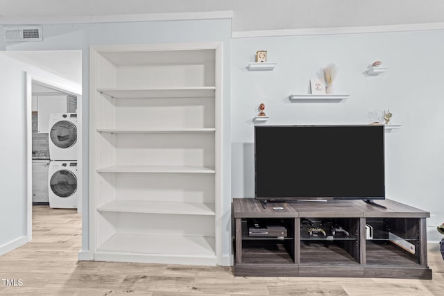 interior space featuring hardwood / wood-style flooring and stacked washing maching and dryer