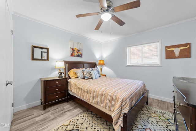 bedroom with crown molding, light hardwood / wood-style floors, and ceiling fan