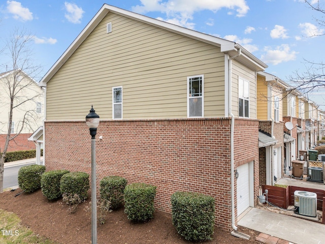 view of property exterior with central air condition unit and a garage