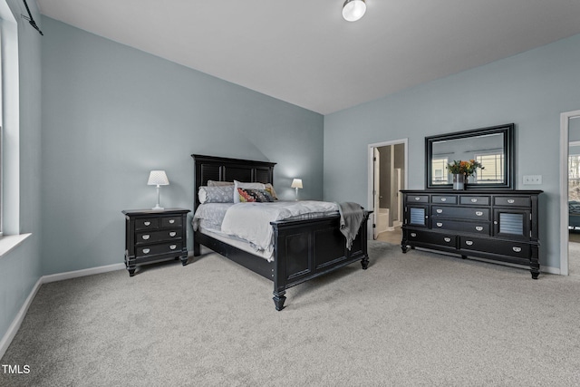 bedroom featuring ensuite bathroom and light carpet