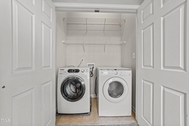 laundry room with washer and dryer and light tile patterned floors