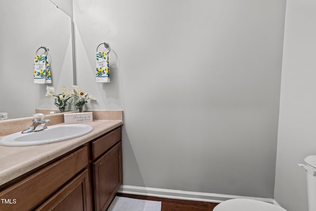 bathroom with toilet, wood-type flooring, and vanity