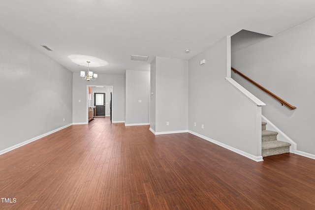 unfurnished living room with dark wood-type flooring and a chandelier