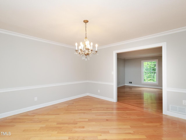 spare room featuring crown molding, a chandelier, and light hardwood / wood-style flooring