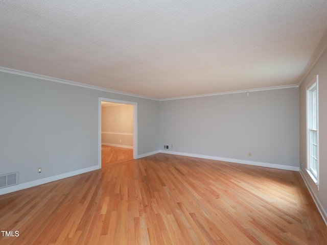 unfurnished room featuring plenty of natural light, a textured ceiling, and light wood-type flooring