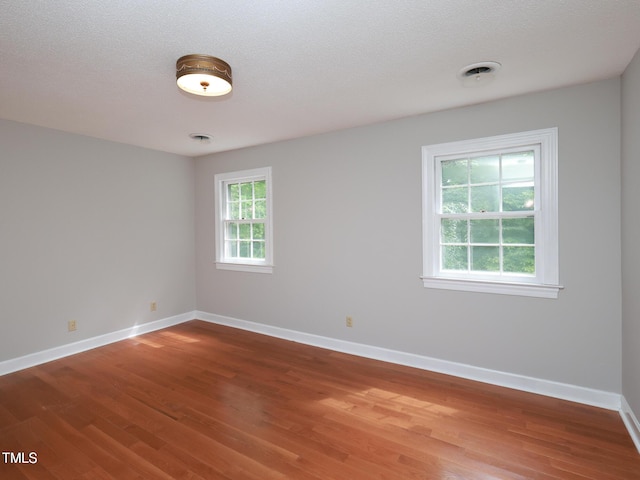 empty room featuring hardwood / wood-style floors and a textured ceiling