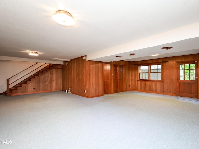 basement with light colored carpet and wood walls