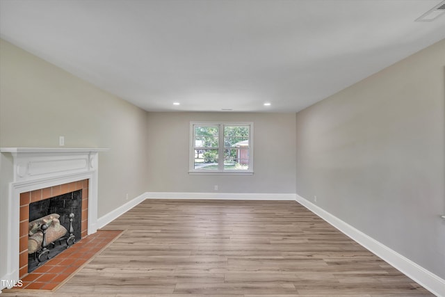 unfurnished living room featuring light wood-type flooring and a fireplace