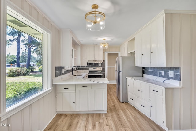 kitchen featuring backsplash, pendant lighting, white cabinets, and stainless steel appliances