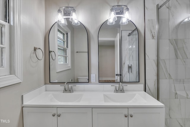 bathroom featuring toilet, an enclosed shower, and vanity