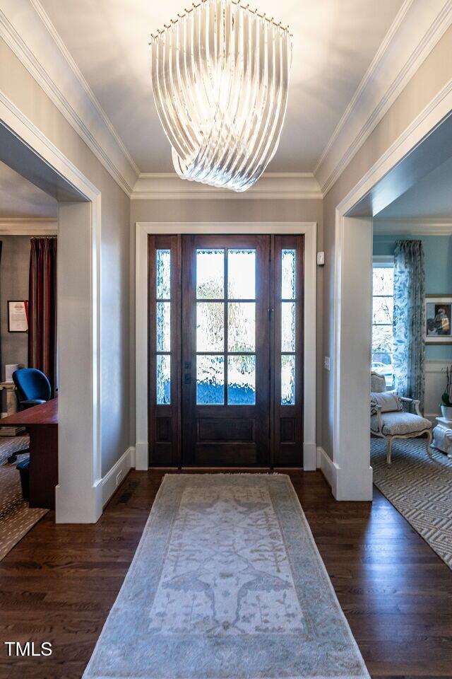 foyer featuring crown molding, a chandelier, and dark hardwood / wood-style flooring