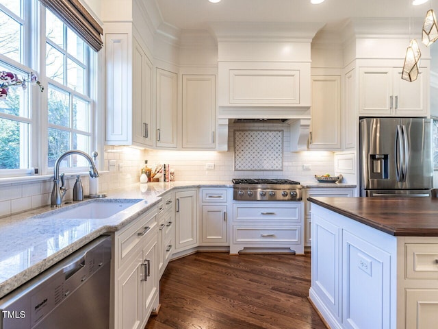 kitchen with dark wood-type flooring, sink, white cabinetry, dark stone countertops, and stainless steel appliances