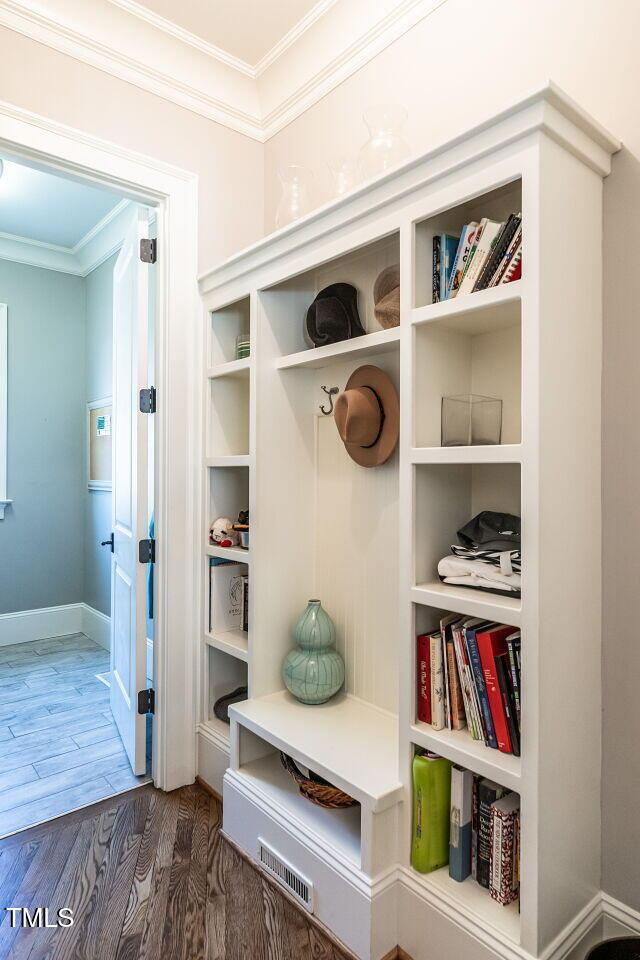 mudroom with dark wood-type flooring and ornamental molding