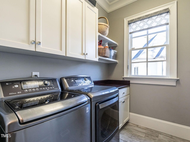 laundry room with washer and dryer, crown molding, cabinets, and light wood-type flooring