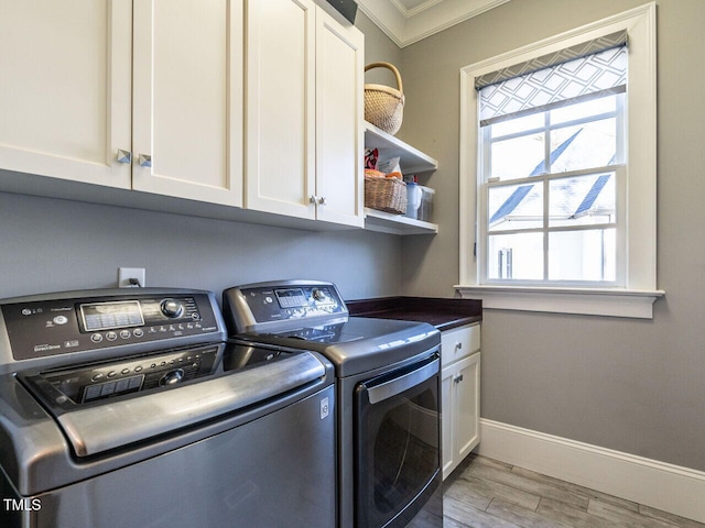 2900 Glenanneve Pl, Raleigh, NC 27608 - laundry room featuring cabinet space, washer and clothes dryer, ornamental molding, baseboards, and wood finished floors