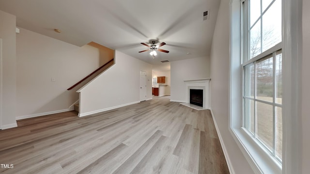 unfurnished living room featuring ceiling fan, light hardwood / wood-style flooring, and plenty of natural light