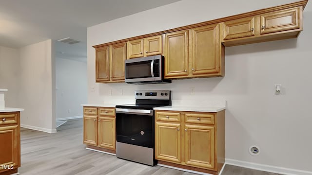 kitchen featuring light wood-type flooring and appliances with stainless steel finishes