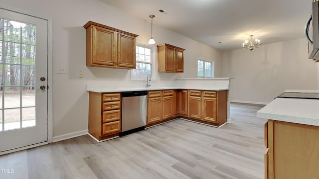 kitchen featuring stainless steel appliances, light wood-type flooring, kitchen peninsula, pendant lighting, and an inviting chandelier