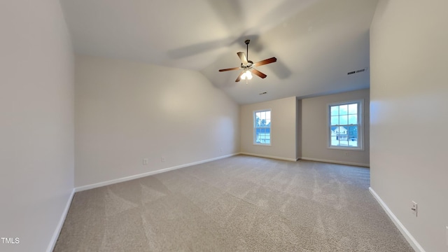 carpeted empty room featuring ceiling fan and vaulted ceiling