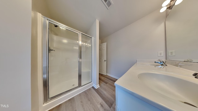 bathroom featuring a shower with shower door, wood-type flooring, and vanity