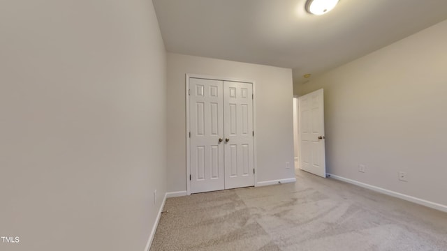 unfurnished bedroom featuring a closet and light carpet