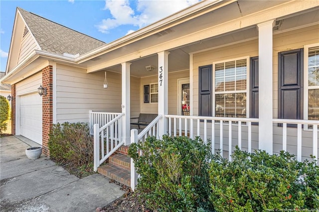 view of exterior entry featuring covered porch and a garage