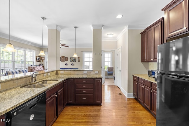 kitchen featuring hanging light fixtures, ornamental molding, sink, and black appliances