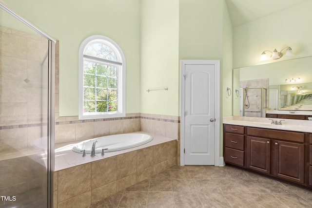 bathroom featuring tile patterned floors, vanity, independent shower and bath, and vaulted ceiling