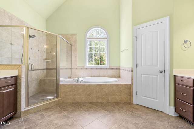 bathroom with independent shower and bath, vanity, lofted ceiling, and tile patterned flooring