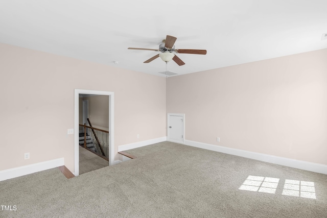 carpeted spare room featuring ceiling fan