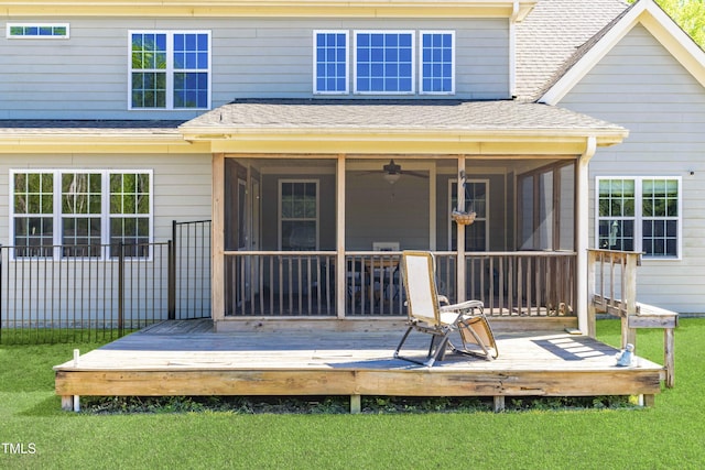 rear view of house with a wooden deck, a yard, a sunroom, and ceiling fan