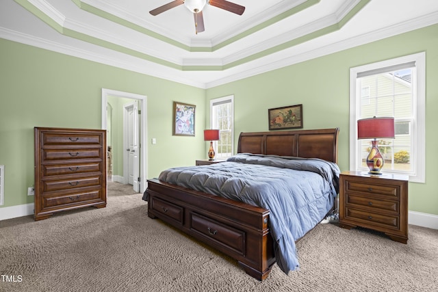 carpeted bedroom featuring multiple windows, a tray ceiling, and ceiling fan