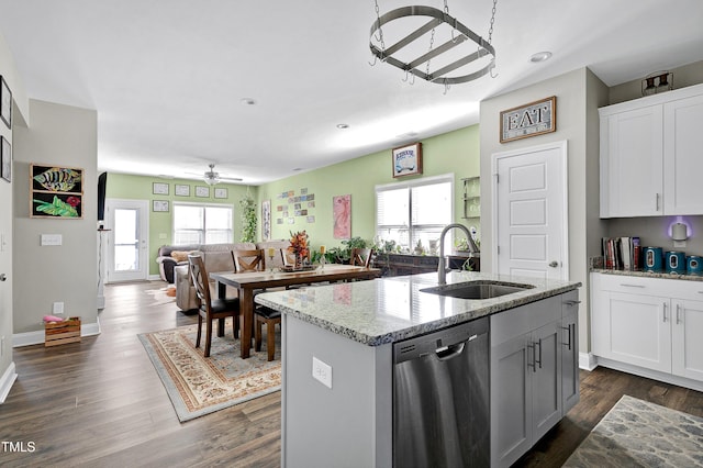 kitchen with dishwasher, white cabinetry, an island with sink, sink, and light stone counters