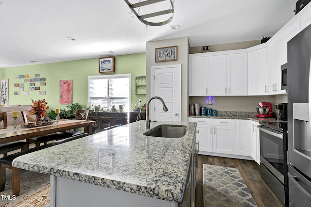 kitchen with sink, white cabinetry, a kitchen island with sink, light stone countertops, and appliances with stainless steel finishes