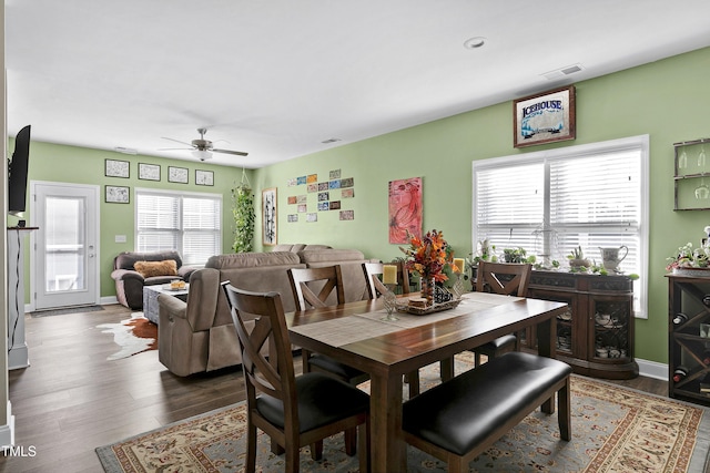 dining space featuring ceiling fan and dark wood-type flooring