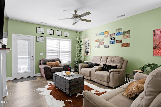 living room with ceiling fan and dark wood-type flooring