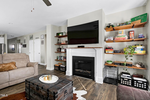 living room with ceiling fan and dark wood-type flooring