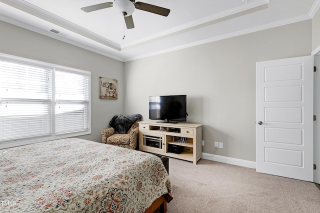 bedroom featuring ceiling fan, a tray ceiling, ornamental molding, and carpet flooring