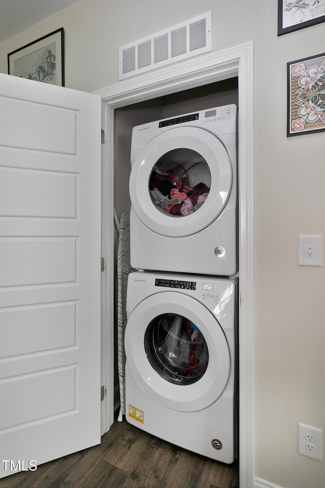 clothes washing area with stacked washer / dryer and dark hardwood / wood-style floors