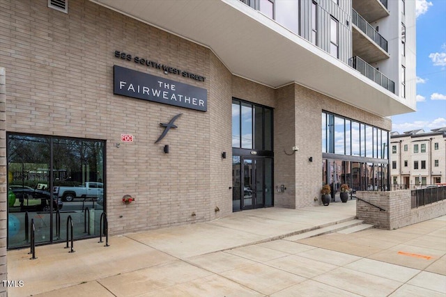 view of exterior entry featuring brick siding