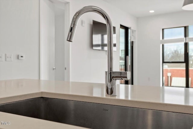 interior space with light countertops, a sink, and recessed lighting