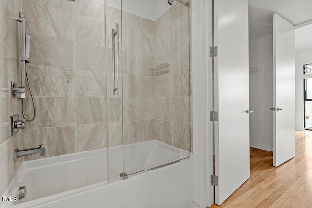 bathroom featuring combined bath / shower with glass door and wood finished floors