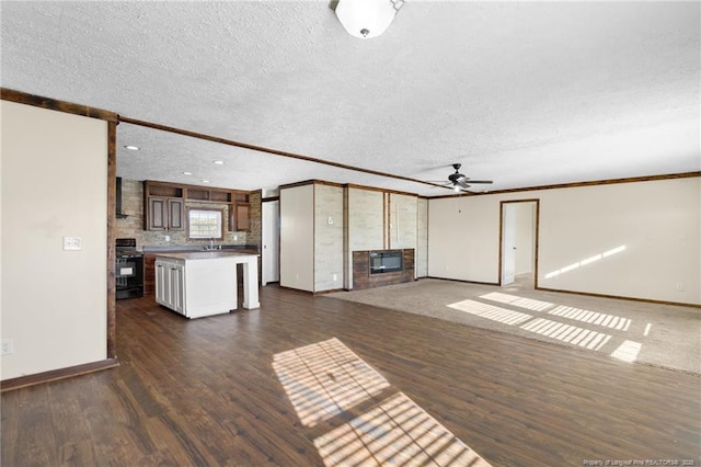 unfurnished living room with sink, a textured ceiling, ceiling fan, and dark hardwood / wood-style floors