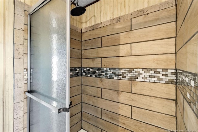 bathroom with wood walls and walk in shower