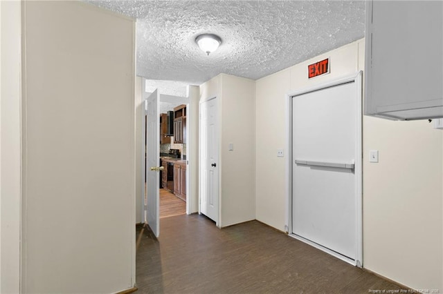 corridor featuring a textured ceiling and dark wood-type flooring