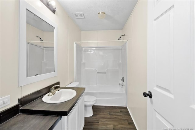 full bathroom with toilet, hardwood / wood-style flooring, a textured ceiling, shower / washtub combination, and vanity